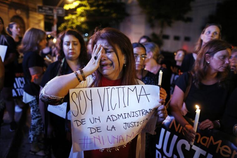 The ex-wife of a judge who said she was attacked by him, cries as she joins a protest against femicides in Asuncion, Paraguay, Thursday, Dec. 21, 2017. According to Women’s Minister Ana Maria Baiardi, there were 48 femicides nationwide this year. The woman, who did not want to give her name, holds a sign that reads in Spanish “I’m a victim of the justice administration.”