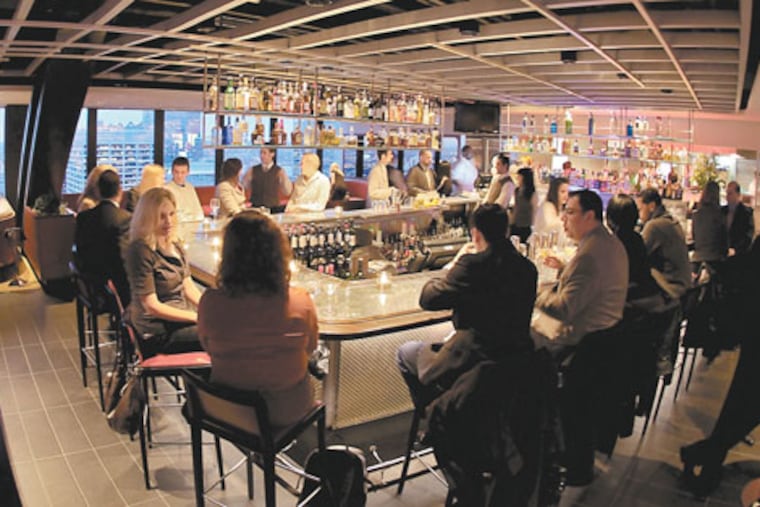 Bar patrons enjoy R2L’s westward view of the city at dusk.