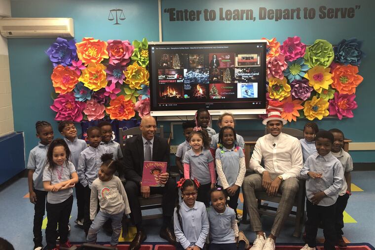 Tobias Harris (right) and superintendent Dr. William Hite (left) read to students at Bethune Elementary School.
