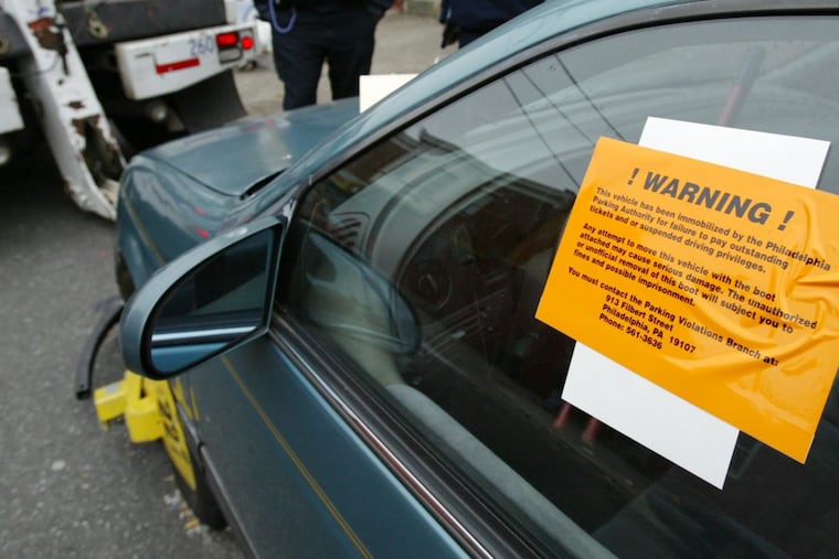 The Philadelphia Parking Authority tows a car away from the 500 block of East Clearfield. The authority’s red light camera program is reportedly under investigation.