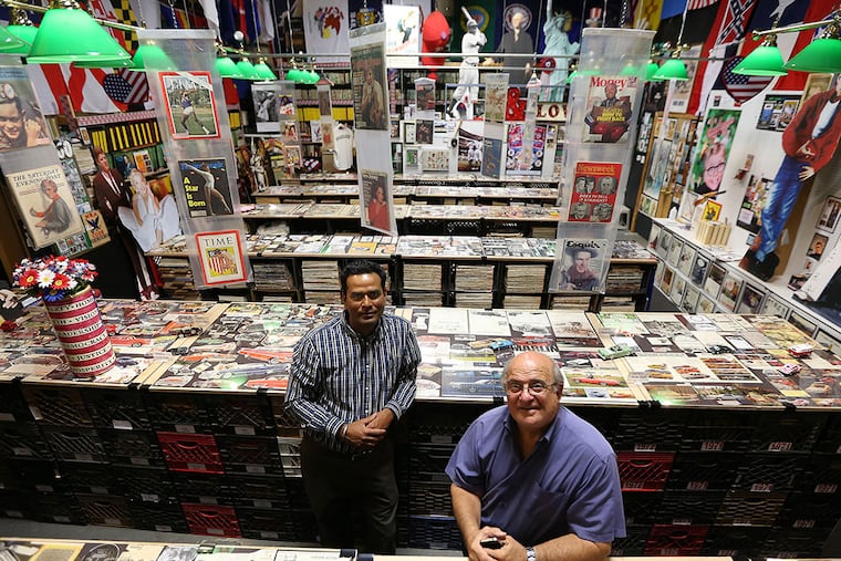 Fran DiBacco (right) created a nostalgia and pop-culture exhibit in Paulsboro out of his collection of vintage magazines and ads, with help from Kamal Kishore (left). "I turned a hobby into a business," he says. DAVID MAIALETTI / Staff Photographer