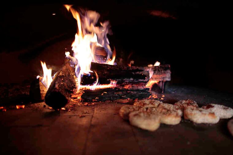 Sesame seed bagels warm up in the custom-built, wood-burning oven. The owners futzed with it for weeks, turning away customers, learning its hot spots and nuances.