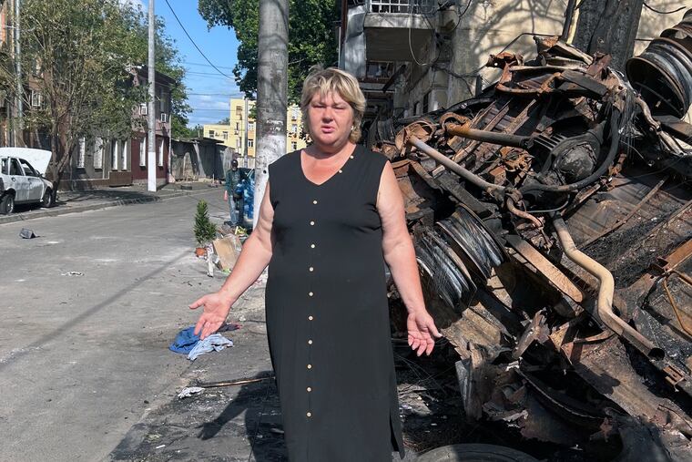 Natalya Dubchek stands next to a minibus destroyed by a Shahed drone. The fire from the explosion torched her home in Odesa, Ukraine.
