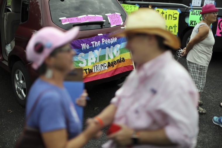 A group of protesters gather near Trump National golf course, where President Trump attended the Women’s U.S. Open on Saturday.