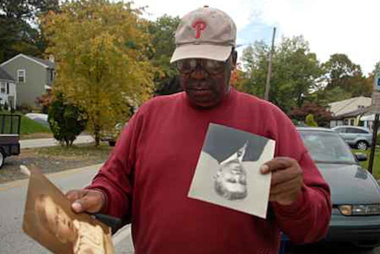 Fred Scott pauses outside the home of Russell Nise after taking out some of the man's belongings to the curb on trash day. ( Tom Gralish / Staff Photographer )