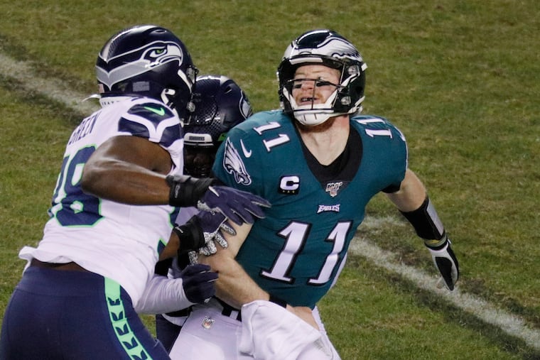 Eagles quarterback Carson Wentz (11) gets pressure in the playoff loss to Seattle. Getting more consistent play from Wentz next season will be the top priority of Doug Pederson's revamped offensive coaching staff.