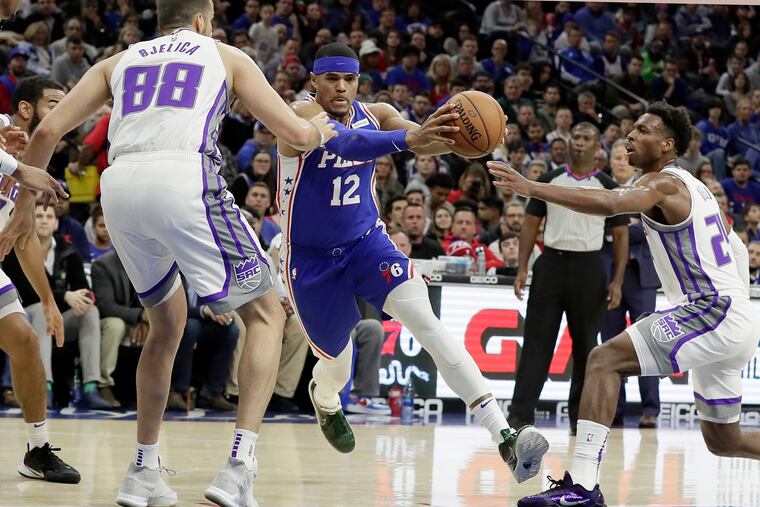 The Sixers' Tobias Harris splits Kings defenders Nemanja Bjelica (88) and Buddy Hield.