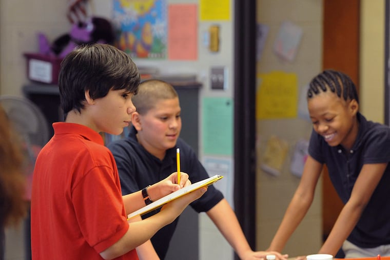 H.A. Brown Elementary School eighth-grade officer Chirstopher Reyes (left with pencil) observes and takes notes while sixth-graders work on a social studies/science project Dec 16, 2014. At H.A. Brown, the eight-grade class officers help the principal evaluate teachers. ( CLEM MURRAY / Staff Photographer )