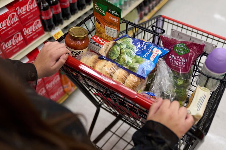 A food shopper pushes a cart of groceries at a supermarket in Bellflower, Calif., in February.