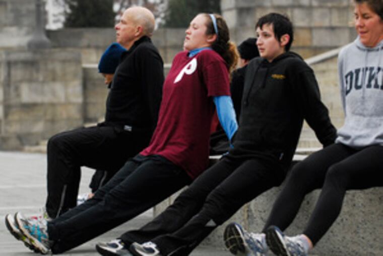 Doing tricep dips at the Art Museum are (from left) Lou Rossman, Nancy Villante, Maggie Hochberg and Chris Costello. Platoon, based on the Main Line, charges participants $80 a month for the exercise program.