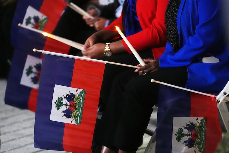 People hold Haitian flags and candles during a vigil at the Little Haiti Cultural Complex after a federal judge blocked the Trump administration from ending temporary immigration status, or TPS, for Haitians, Feb. 3, 2026, in North Miami. On Thursday, the Supreme Court allowed Trump to strip those humanitarian protections and deport people.
