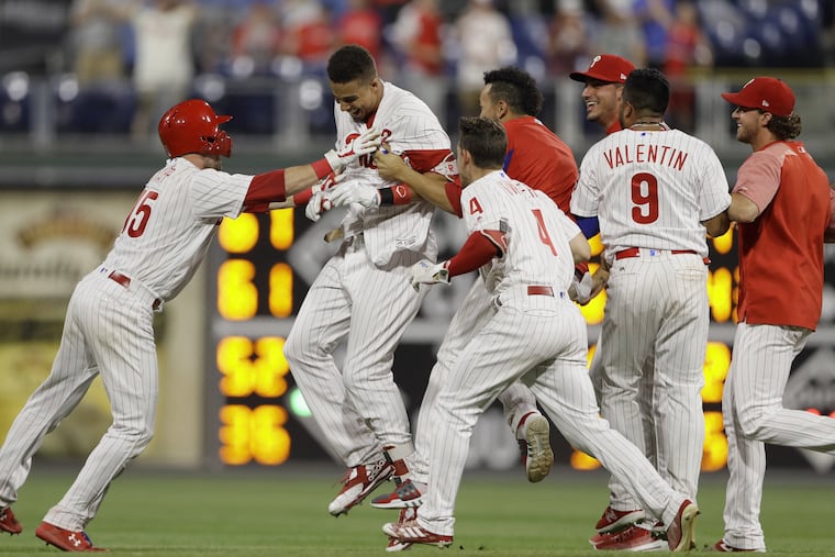 Aaron Altherr is mobbed by his teammates after hitting a walk-off double in the 10th against St. Louis Monday.