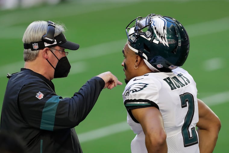 Eagles quarterback Jalen Hurts listens to head coach Doug Pederson after Hurts committed an intentional grounding penalty in the first quarter of Sunday's 33-26 loss to the Arizona Cardinials.