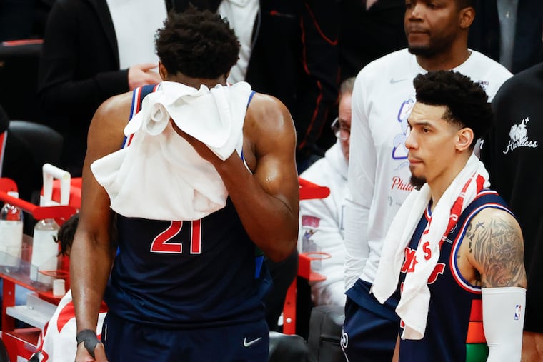 Sixers center Joel Embiid wipes his face standing next to teammate Sixers forward Danny Green at the end of game four of the first-round Eastern Conference playoffs against the Toronto Raptors on Saturday, April 23, 2022 in Toronto. The Raptors beat the Sixers 110-102.