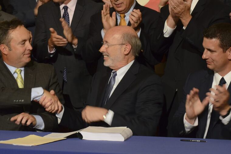 Democratic Gov. Wolf shakes hands with Senate Majority Leader Jake Corman earlier this month after signing legislation. At right is House Majority Leader Dave Reed.