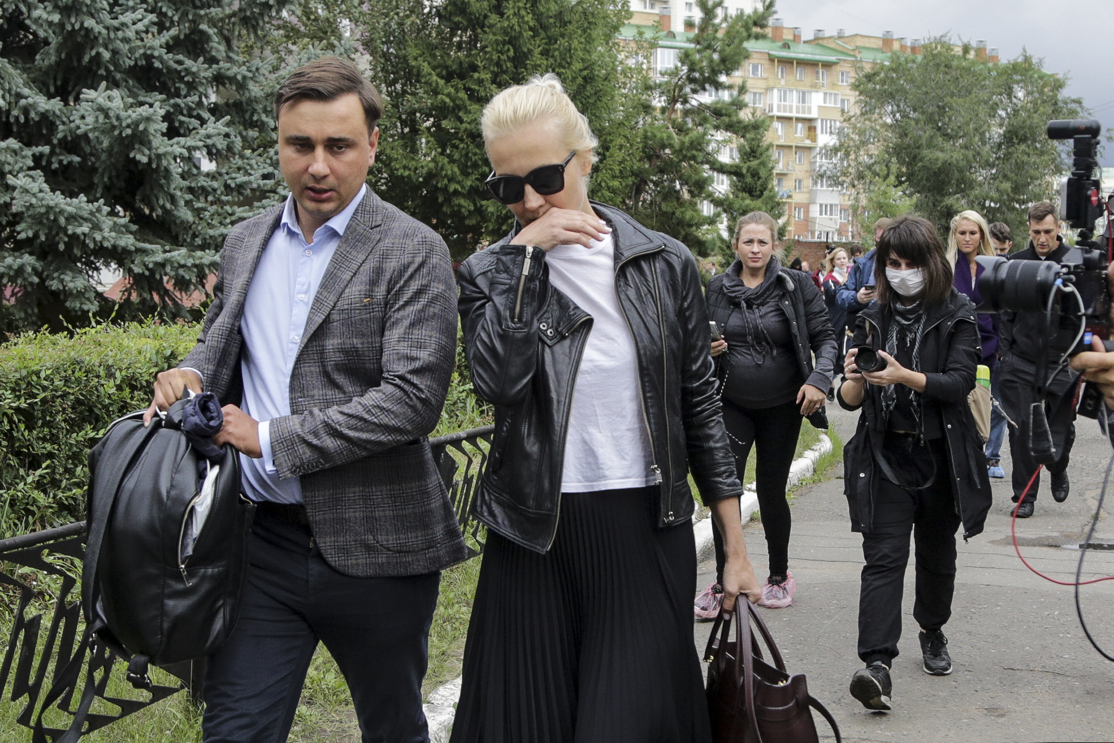 Alexei Navalny's wife Yulia, center, and Navalny's colleague Ivan Zhdanov, left, arrive at the Omsk Ambulance Hospital No. 1, intensive care unit where Alexei Navalny was hospitalized in Omsk, Russia, on Friday.