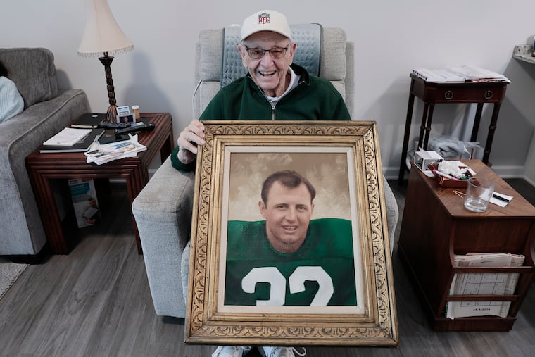 Joe Pagliei holds a painting depicting his time with the Eagles.