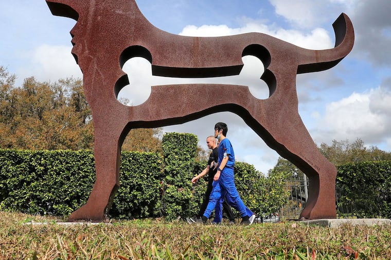 Pedestrians taking a lunchtime stroll are framed by the “Big Dog” sculpture on the garden path at the Mennello Museum of American Art in Orlando. Arts groups, including museums, live theaters, some zoos and more, may be able to take advantage of a new grant program from the Small Business Administration.