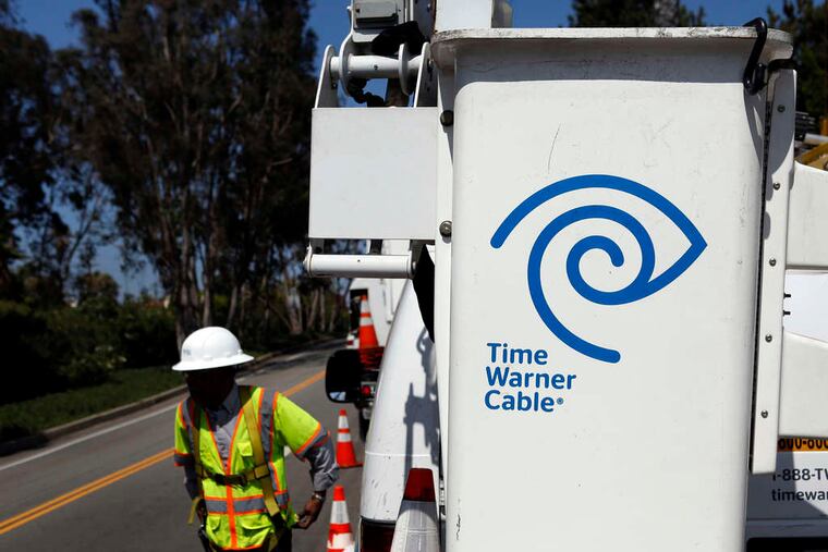 A Time Warner Cable technician checks a WiFi hot spot in Calif. Comcast's deal to acquire Time Warner Cable faces regulatory scrutiny.