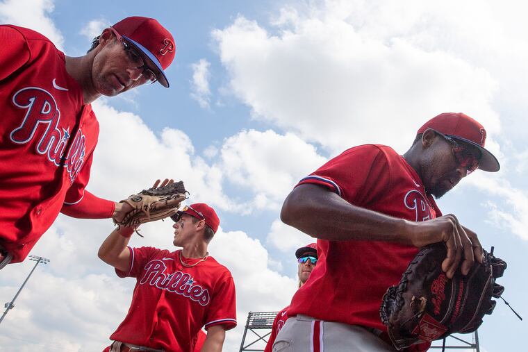 Philadelphia Phillies, Drew Maggi, left, congratulates Nick Maton, center, next to Luis Garcia, as they enter the dugout in the 4th inning against the Atlanta Braves at CoolToday Park in North Port, Florida.