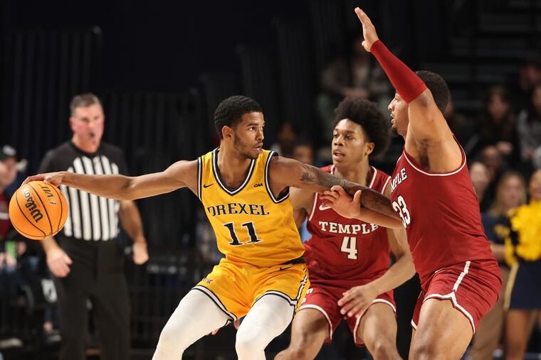 Justin Moore (left) of Drexel drives against Jordan Riley (center) and Sam Hofman of Temple on Nov. 14, 2023.