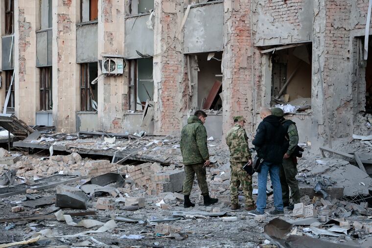 Investigators inspect a site after shelling near an administrative building in Donetsk, the capital of Donetsk People's Republic, eastern Ukraine.