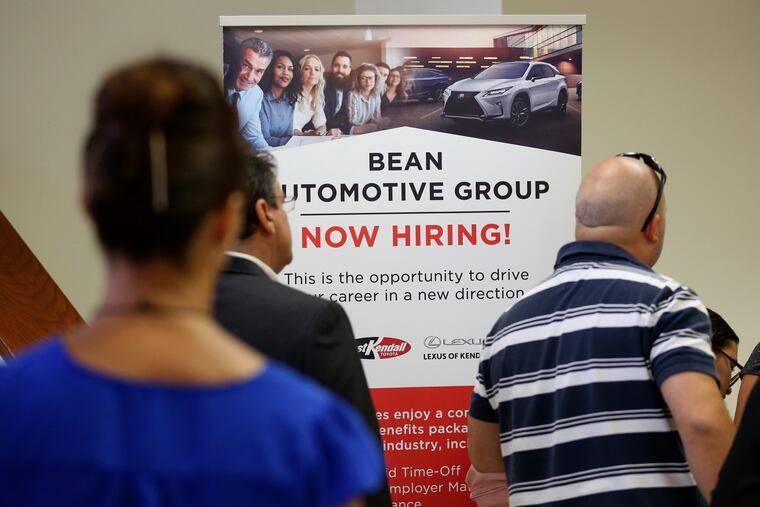 In this Sept. 18, 2019, file photo people stand in line to inquire about jobs available at the Bean Automotive Group during a job fair in Miami. On Friday, Jan. 10, 2020, the U.S. government issues the December jobs report.