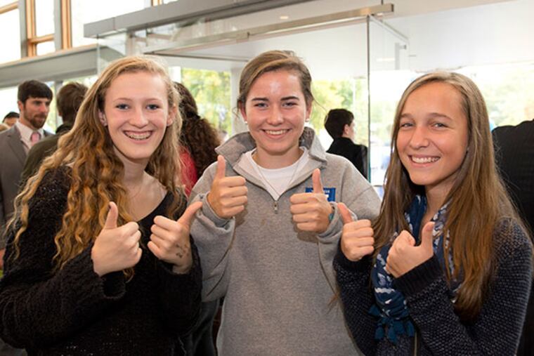 Mercersburg Academy ninth-grade students Morgan Steiner, Devon Stuzin, and Elizabeth Smilek give their sign of approval to the announcement that alumna Deborah Simon ’74 is pledging $100 million to Mercersburg. Credit: Courtesy Mercersburg Academy