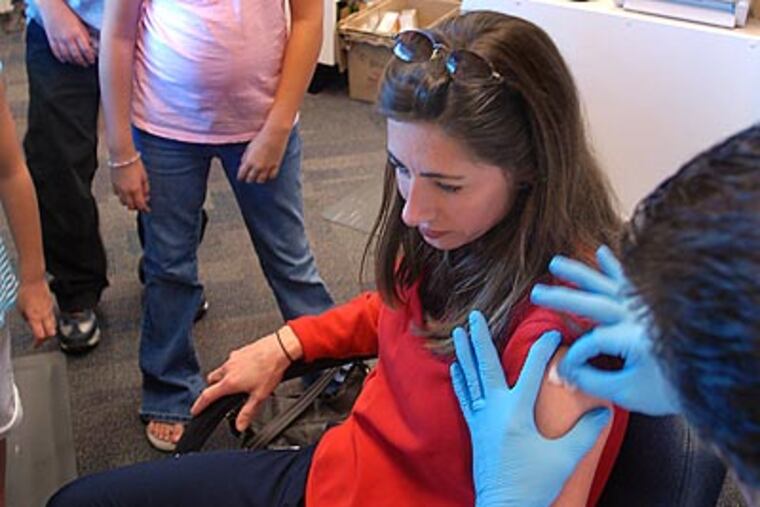 Jamie Chaet of Voorhees gets a flu shot at a Walgreens pharmacy in Marlton. (Tom Gralish/Staff Photographer)