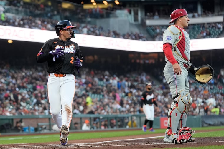 The Giants' Willy Adames runs home to score against the Phillies and catcher J.T. Realmuto during Tuesday night's game in San Francisco.