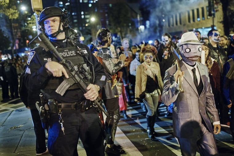 Heavily armed police guard as revelers march during the Greenwich Village Halloween Parade, Tuesday, Oct. 31, 2017. New York City’s always-surreal Halloween parade marched on Tuesday evening under the shadow of real fear, hours after a truck attack killed several people in what authorities called an act of terror.