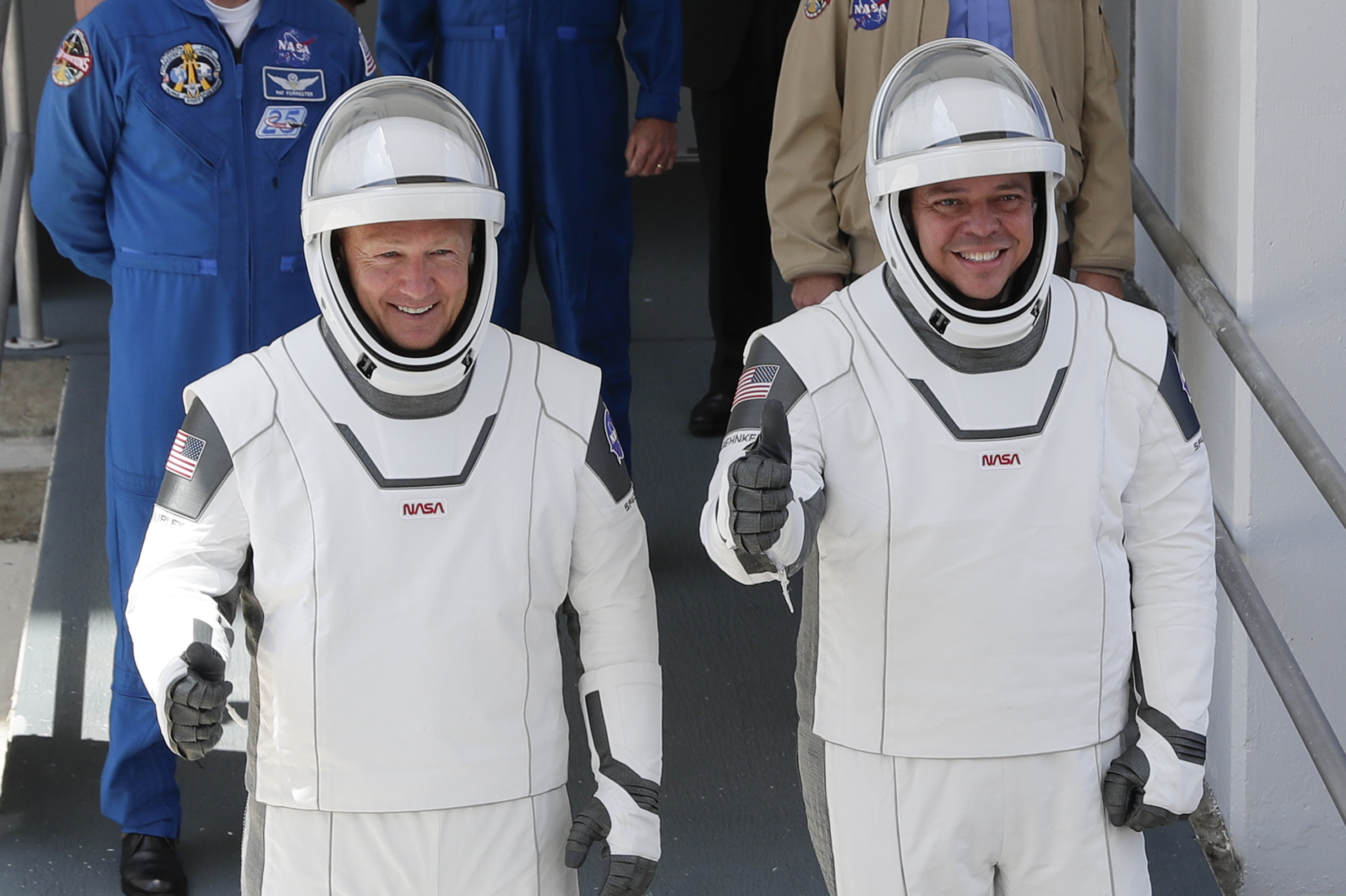 NASA astronauts Douglas Hurley, left, and Robert Behnken walk out of the Neil A. Armstrong Operations and Checkout Building on their way to Pad 39-A, at the Kennedy Space Center in Cape Canaveral, Fla., Saturday, May 30, 2020. The two astronauts will fly on a SpaceX test flight to the International Space Station. For the first time in nearly a decade, astronauts will blast into orbit aboard an American rocket from American soil, a first for a private company.