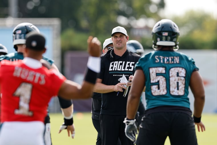 Eagles offensive coordinator Sean Mannion (center) watches the offense during training camp earlier this month.