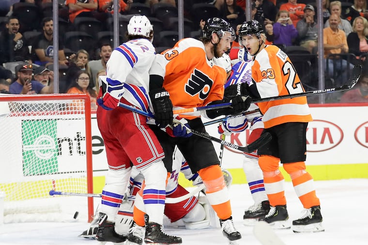 Flyers center Kevin Hayes (center) puts a first-period deflection past Rangers goalie Igor Shesterkin, much to the delight of teammate Oskar Lindblom (right) on Saturday night at the Wells Fargo Center.