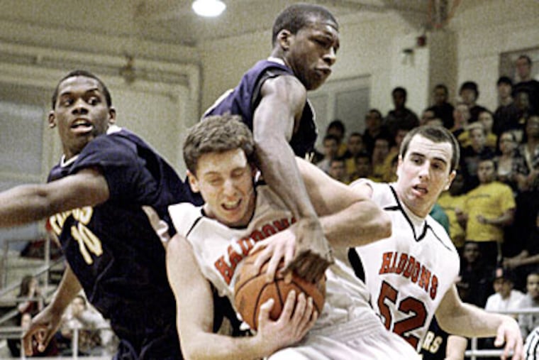 Haddonfield's Kevin Davis (center) fights off Collingswood defenders to hold on to the rebound. (Elizabeth Robertson/Staff Photographer)