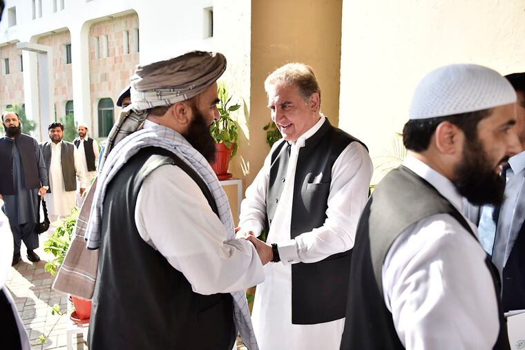 In this photo released by the Foreign Office, Pakistan's Foreign Minister Shah Mehmood Qureshi, center, receives members of Taliban delegation at the Foreign Office in Islamabad, Pakistan, Thursday, Oct. 3, 2019. Senior Taliban leaders are meeting with Qureshi in Islamabad as part of a push to revive an Afghanistan peace deal that has included stops in Russia, China and Iran.