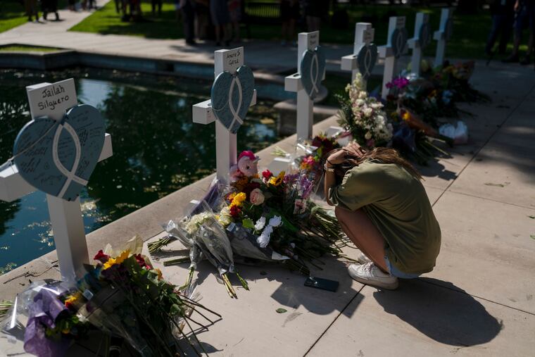 Elena Mendoza, 18, grieves in front of a cross honoring her cousin, Amerie Jo Garza, one of the victims killed in this week's elementary school shooting in Uvalde, Texas.