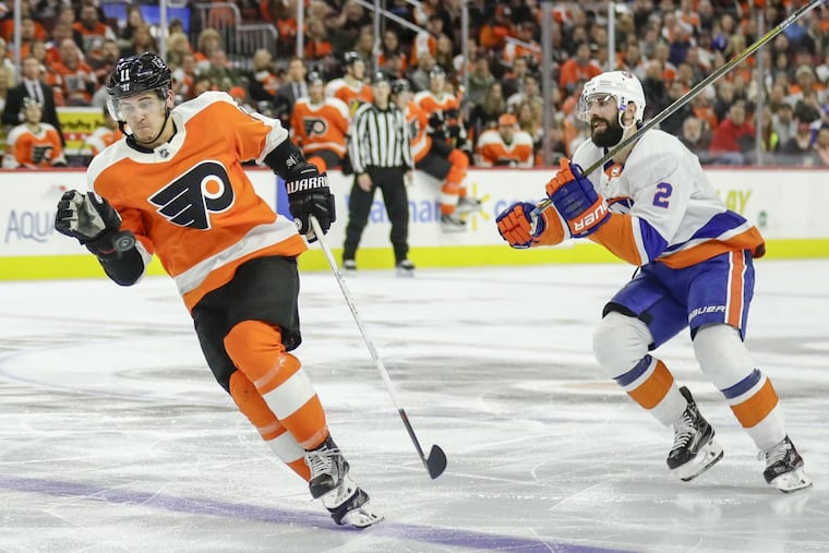 The Philadelphia Flyers' Travis Konecny, left, plays the puck during a third-period breakaway past New York Islanders defenseman Nick Leddy at the Wells Fargo Center in Philadelphia on Friday, Nov. 24, 2017. The Isles won, 5-4, in overtime.