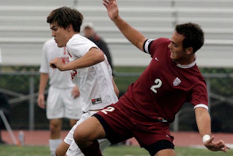 Neshaminy senior midfielder Bob Shegda (left) tries to direct the ball past Lower Merion's Danny Diehl.