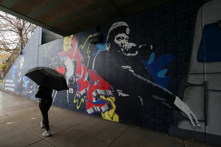 A pedestrian walks past the new mural dedicated to Philly’s hip-hop culture underneath the train tracks at 900 Cecil B. Moore Ave. in North Philadelphia on Tuesday, Dec. 6, 2022.