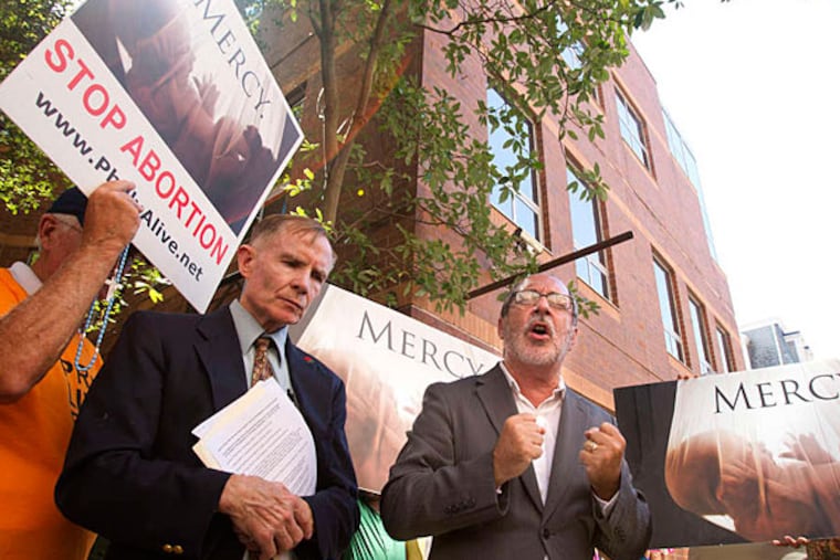 Mike McMonagle (left), the Rev. Patrick Mahoney and other members of the anti-abortion group Philly Alive pray outside Planned Parenthood at 12th and Locust streets Thursday.