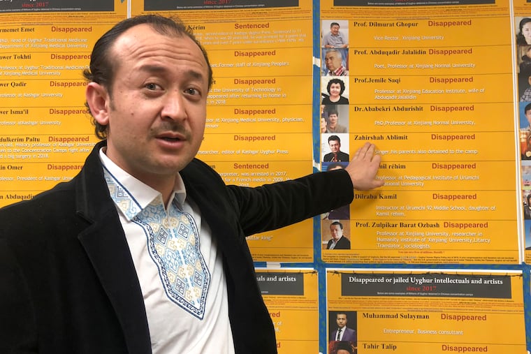 Abudwaris Ablimit points to a photo of his brother during a gathering to raise awareness about loved ones who have disappeared in China's far west, in Washington on Feb. 24, 2019. The western region of Xinjiang has been subject to a severe security crackdown in recent years that has made surveillance cameras and police checkpoints ubiquitous.