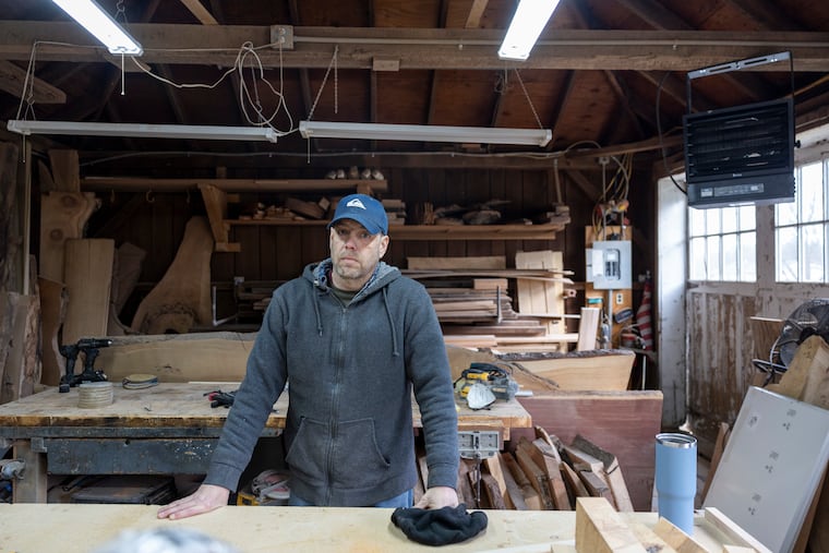 Patrick Melcher poses for a portrait at his business, Nature’s Edge Woodwork, near Downingtown. He has paid thousands this winter to heat his old stone farmhouse and his workshop on the same property.