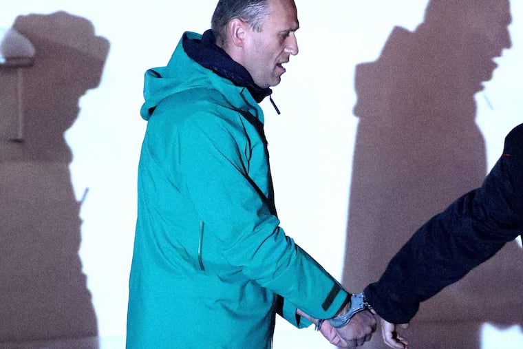 Russian opposition activist Alexei Navalny, detained upon arrival at Sheremetyevo International Airport on Jan. 17, 2021, is escorted by a police officer outside the 2nd Department of the Russian Interior Ministry Directorate for Khimki. The Khimki City Court has put Navalny in custody until Feb. 15.