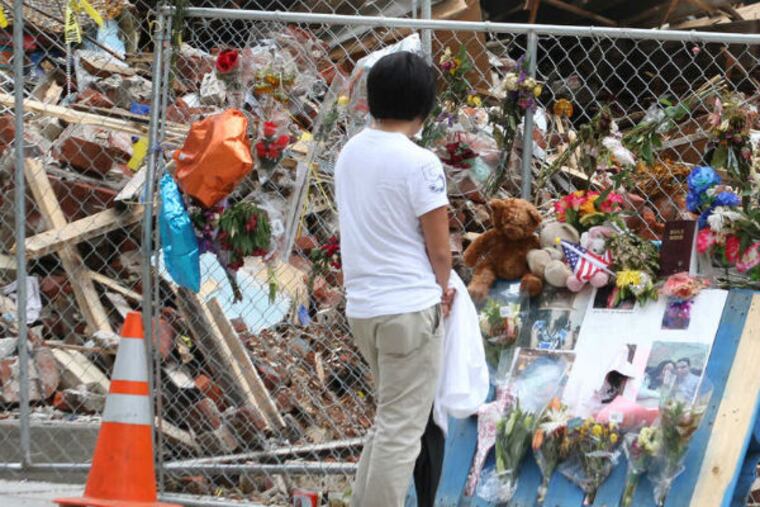 The aftermath of the 2013 building collapse in Center City is viewed by a passerby. (Charles Fox / Staff Photographer)