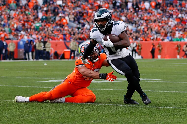 Eagles running back Kenneth Gainwell runs with the football past Denver Broncos safety Kareem Jackson on Sunday, November 14, 2021 in Denver.