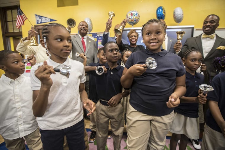Saiyan Stewart (from left), Kahreem Braboy, and Sanaya Meade, all 7, ring in the new school year in the classroom of Lisa Johnson at Pennell Elementary School on Tuesday, along with City of Philadelphia officials.