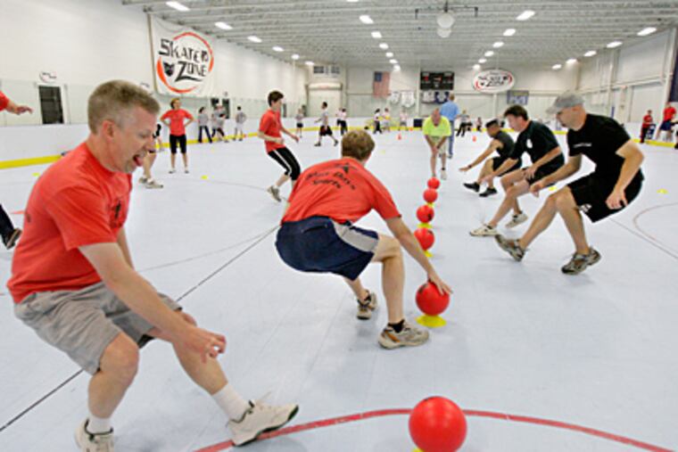 Ball Dawgs player Jeff "Boner" Hammon of Haddonfield (left foreground)
races to the ball in a match against Cajones Del Fuego at the Flyers Skate Zone in Voorhees. ( Elizabeth Robertson / Staff Photographer )