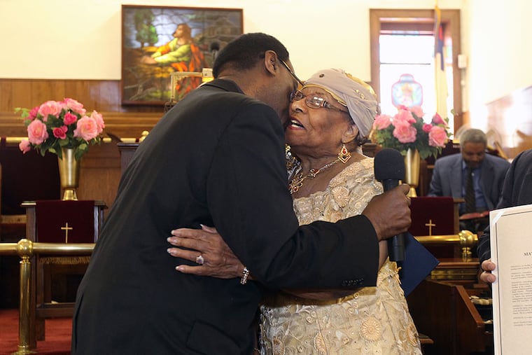 Gwendolyn Faison, right, gets a big hug from State Assemblyman Whip Wilson during a celebration of her 90th birthday on Sunday morning. MICHAEL BRYANT / Staff Photographer