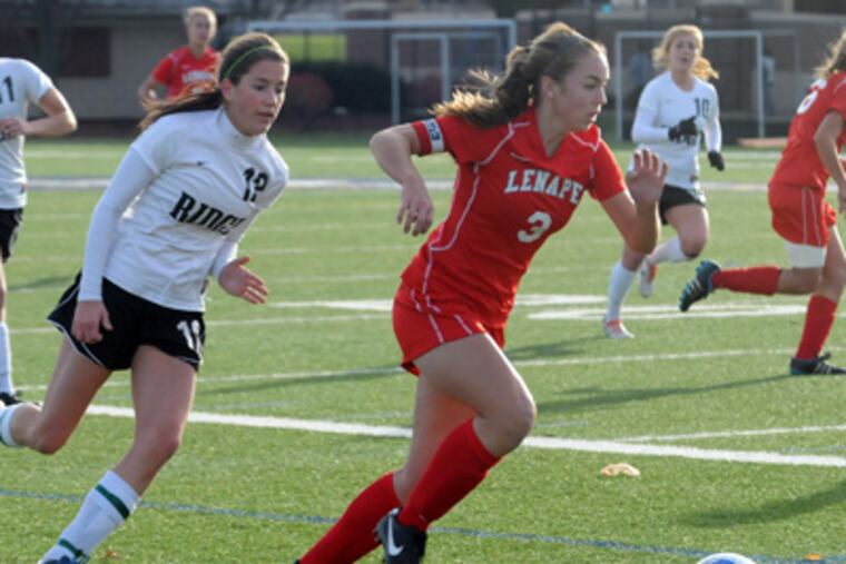 Lenape’s Katie Rigby (right) races ahead of a Ridge player during the state Group 4 final Nov. 19. Rigby scored a goal in the Indians’ 2-0 win; she had 21 goals and 15 assists overall. (Curt Hudson / For The Inquirer)